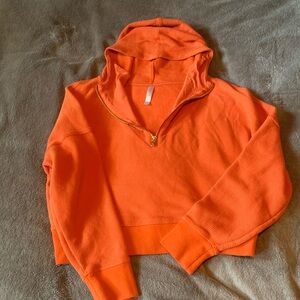 Fabletics Vibrant Orange quarter zip with hood